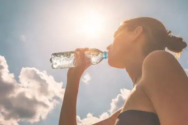 Hydration: The Secret Ingredient for a Toned Stomach and Enhanced Fitness 3 Image of woman drinking water to hydrate Kingswinford after run.